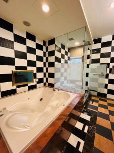 a large bath tub in a bathroom with checkered walls at Walker Hotel - Chengde in Taipei