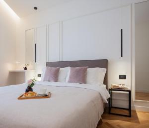 Un dormitorio con una cama con una bandeja de comida. en Maia Flora Taormina Apartments en Taormina
