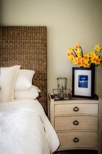 Nest Farmhouse في Docking: غرفة نوم بها سرير وخزانة وعليها زهور