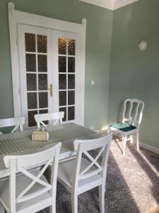 a dining room with a table and white chairs at Medusa Apartment in Krakow