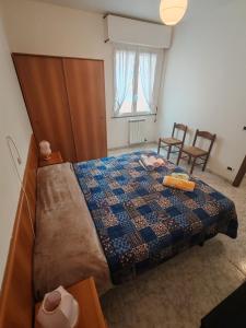 a bedroom with a bed and two chairs and a window at Casa Martesa in Loano
