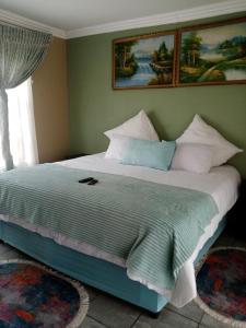 Jubie's Guest Lodge في فيرينجنغ: غرفة نوم بسرير كبير مع مخدات