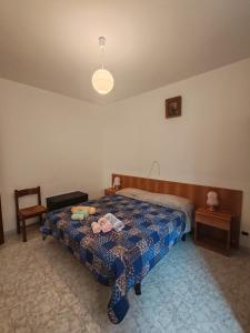 a bedroom with a bed with a blue comforter at Casa Martesa in Loano