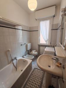 a bathroom with a tub and a sink and a toilet at Casa Martesa in Loano