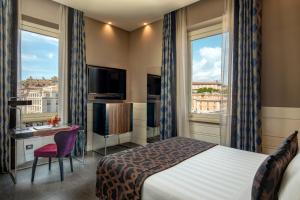 a hotel room with a bed and a desk and two windows at The Glam in Rome