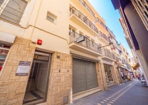 un bâtiment avec des portes de garage sur le côté d'une rue dans l'établissement Agi Gloria Rooms, à Roses