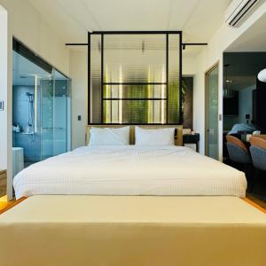 a bedroom with a large white bed with a large window at La Vie - Ocean Paradise in Toucheng