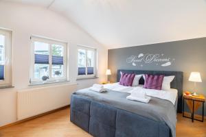 - une chambre avec un grand lit et des oreillers violets dans l'établissement Villa Alt_Ahlbeck, à Ahlbeck