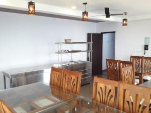 a dining room with a glass table and chairs at Blossom Bed Resort Vagamon by Lexstays in Vagamon