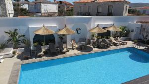 a swimming pool with chairs and umbrellas at Bay C in Alacati