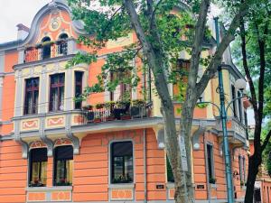 a orange building with a balcony on a street at My Guest Rooms in Plovdiv
