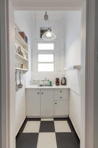 una cucina bianca con pavimento a scacchi in bianco e nero di Cute and central apt for 3 ad Atene