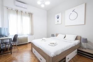 una camera bianca con letto e scrivania di Cute and central apt for 3 ad Atene