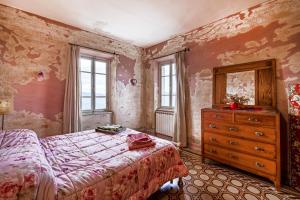 a bedroom with a bed and a dresser and windows at Appartamento Giovanni - Relax Among Green - Happy Rentals in Camaiore