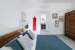 una camera da letto con un letto e un vestito rosso appeso al muro di San Lorenzo - Rosmarino a Reitani