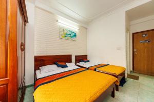 2 letti in una camera con giallo e bianco di SPOT ON 1227 Binh Minh Hotel a Hanoi