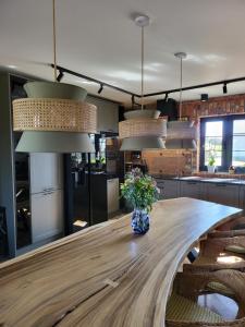 una cocina con una mesa de madera y un jarrón de flores en Stary Dom nad Wrześnicą, 