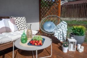 a table with a tray of fruit on a patio at MalinoweLove - 3 pokoje, parking, ogród in Kraków