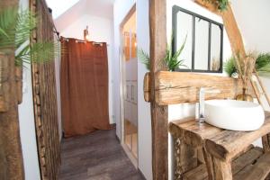La salle de bains est pourvue d'un lavabo sur une table en bois. dans l'établissement LE RELAIS DES CALECHES - La Jungle Room, 