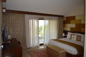 a hotel room with a large bed and a window at Welcomhotel by ITC Hotels, Kences Palm Beach, Mamallapuram in Mahabalipuram