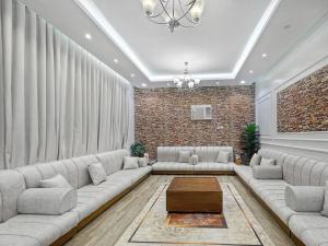 een woonkamer met een grote bank en een tafel bij شقة خمس غرف علي طريق السودة in Abha