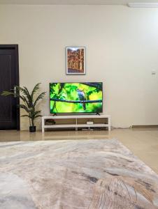 sala de estar con TV de pantalla plana en una pared blanca en Comfort Bed Inn en Dubái