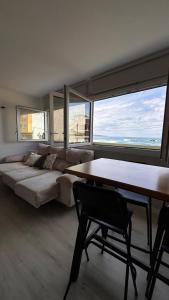 a living room with a bed and a table and some windows at Blue Sea in Moya