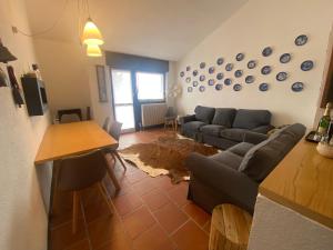 ein Wohnzimmer mit einem Sofa und einem Tisch in der Unterkunft Enjoy Sauze d'Oulx in Sauze dʼOulx