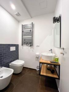 a white bathroom with a sink and a toilet at La residenza del viale in Treviglio