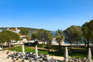 un grupo de mesas y sillas con sombrillas en un parque en Aktis Hotel, en Palaia Epidavros