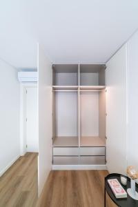 Lusíadas 53 2ºD - Beautiful two-bedroom apartment في لشبونة: خزانة مع أبواب زجاجية وطاولة