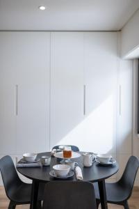 Lusíadas 53 2ºD - Beautiful two-bedroom apartment في لشبونة: طاولة سوداء مع كراسي وصحن من الطعام عليها