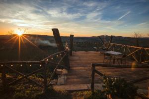 a wooden deck with a bench and the sunset at Sotto L'Ulivo in Montepulciano