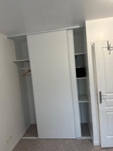 Habitación con armario y puerta blanca en Chambre d’hôte à 13 minutes de Disneyland, en Champs-Sur-Marne