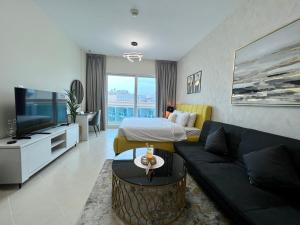 sala de estar con cama y sofá en Cosmos Living Stunning Apt in Lago Vista IMPZ en Dubái