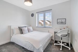 een witte slaapkamer met een wit bed en een bureau bij Scenic getaway, open plan home! 2bed park for free in Eaglesham