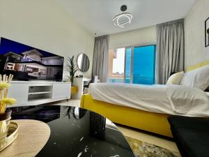 - une chambre avec un grand lit et un canapé jaune dans l'établissement Cosmos Living Stunning Apt in Lago Vista IMPZ, à Dubaï 32 autres photos