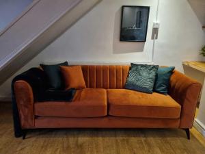 a brown couch with pillows on it in a room at Green Cottage - Snowdonia in Llanllechid
