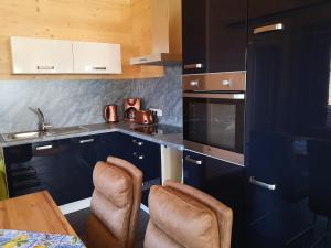 a kitchen with blue cabinets and a table and chairs at Ferienwohnung Am Roten Berg in Peiting