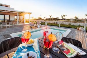 een tafel met wijnglazen en eten erop naast een zwembad bij San Lorenzo - Ulivo in Reitani