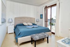 een slaapkamer met een bed met blauwe lakens en kussens bij San Lorenzo - Ulivo in Reitani