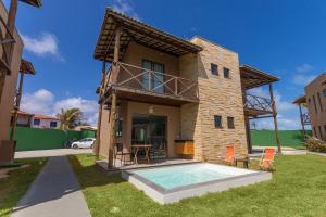 a house with a swimming pool in front of it at Beachfront Duplex #A10 em Barro Preto by Carpediem in Prainha