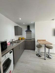 uma cozinha com uma máquina de lavar roupa e uma mesa em Urban Stay - Contractor accommodation em Grimsby