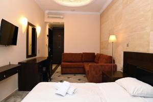 Habitación de hotel con cama y sofá en Aktis Hotel, en Palaia Epidavros