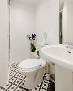 a white bathroom with a toilet and a sink at Spacious & stylish 1-bed flat in Primrose Hill in London