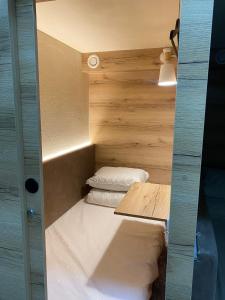 a small room with two pillows in it at AQ Capsule Hostel in Almaty
