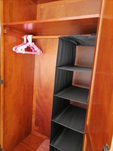 a closet with black shelves and pink shoes in it at Beachfront Cozy Studio in Ban Phe