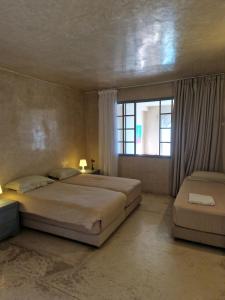 1 dormitorio con 2 camas y ventana en L'Oum Errebia en Azemmour