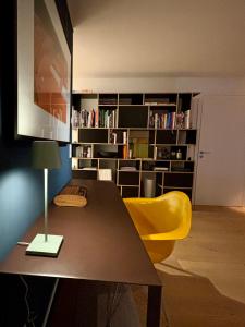 - un salon avec un bureau et une chaise jaune dans l'établissement großzügiges Luxusappartement 106qm - Dachterrasse, à Bad Aibling