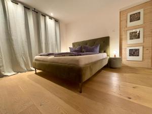 a bedroom with a large bed with purple pillows at Luxusappartement Hochries - 106qm mit sonniger Dachterrasse in Bad Aibling